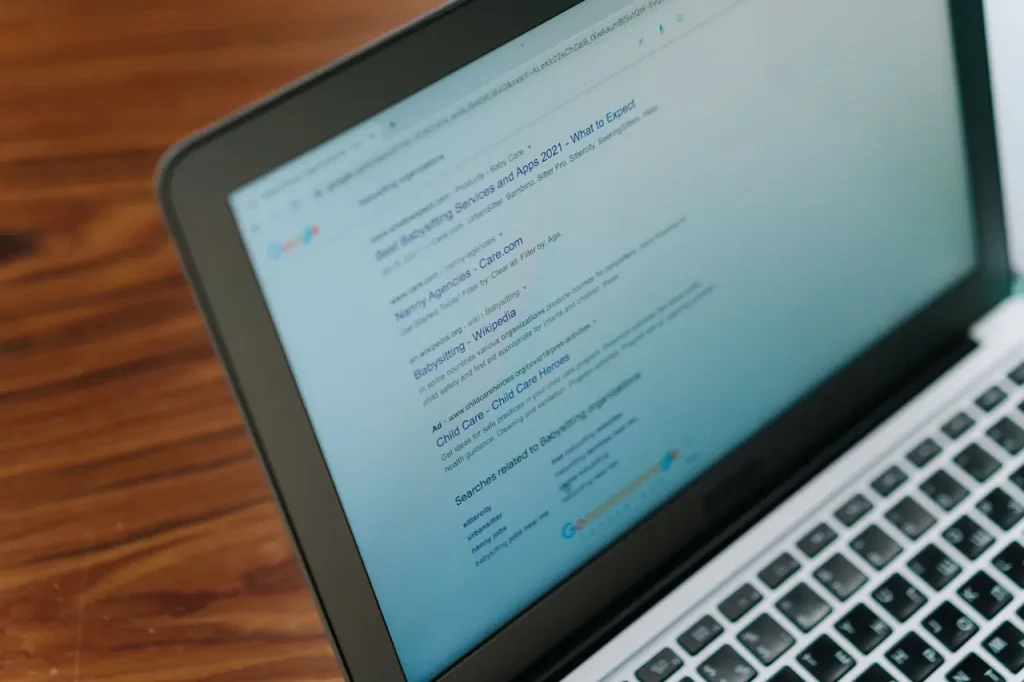 Laptop screen showing Google search results for babysitting services, illustrating website visibility and indexing